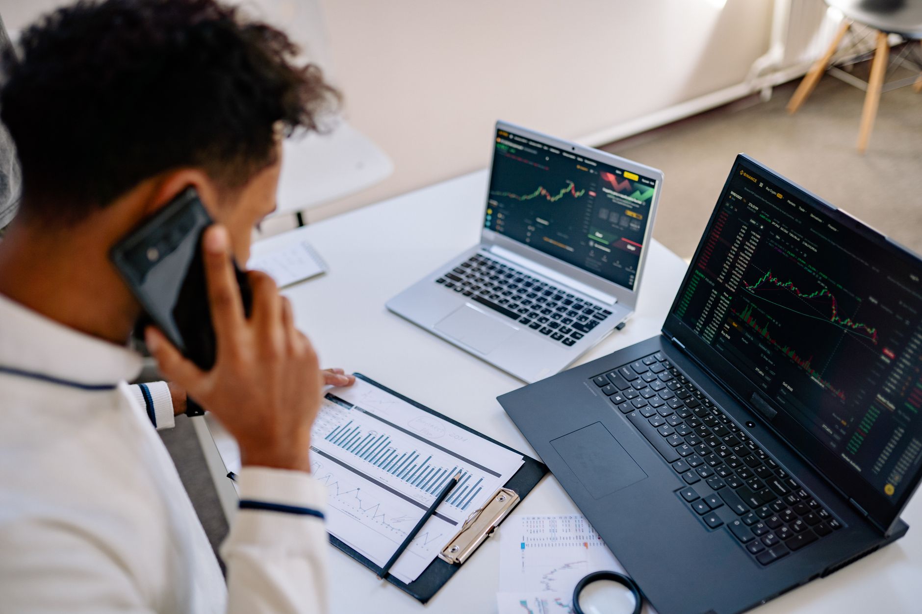a person on the phone reporting a scam while sitting at a desk with a laptop