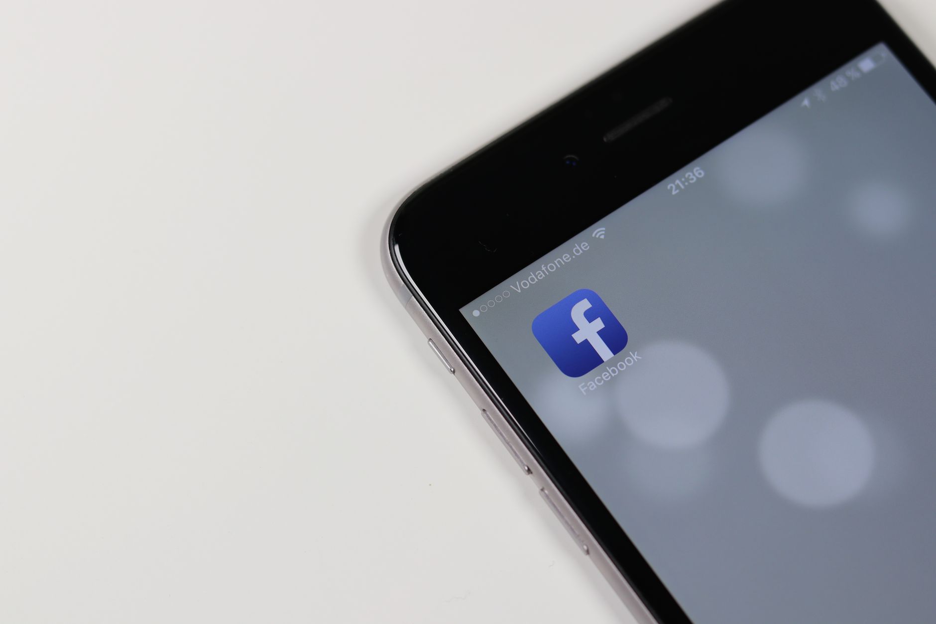 senior woman checking Facebook privacy settings on a smartphone at home
